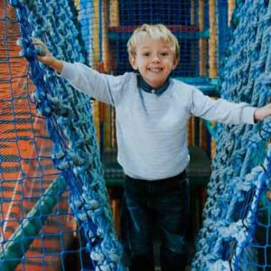 Child climbing on netting in play area