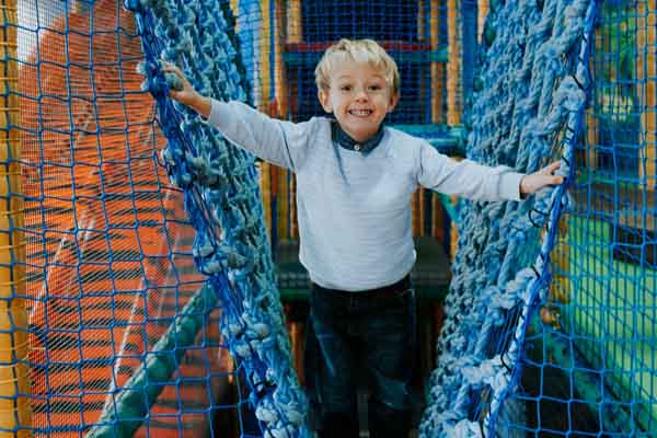 Child climbing on netting in play area