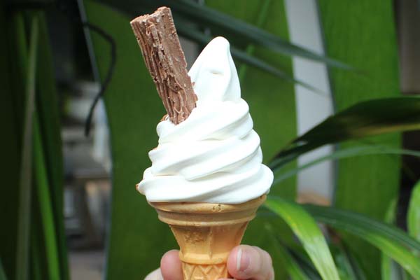 Whippy ice cream in cone with a flake.